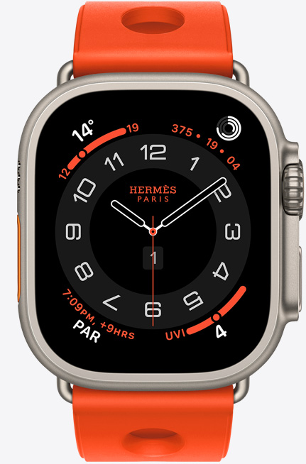 Apple Watch Hermès Ultra 3, Circular analog watch face, (hour, minute and second hands, complications: Weather, activity rings, Paris time and UV Index), titanium case, natural colour, right side exterior, Digital Crown, raised side button, paired with Scub'H Diving band, orange néon colour (bright orange), moulded rubber material, circular cut-outs centred