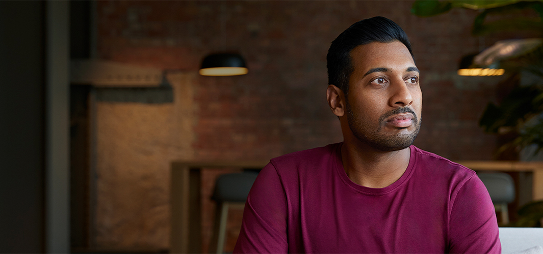 Amar sitzt drinnen und schaut nach links.