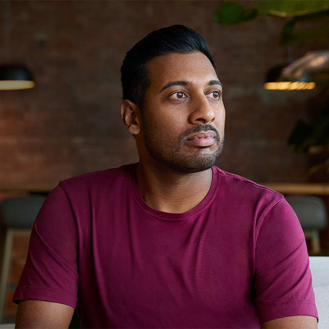 Amar sitzt drinnen und schaut nach links.