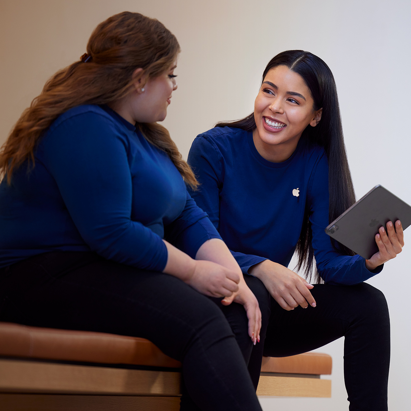 Carissa 拿著 iPad 與另一位 Apple Retail 員工交談。