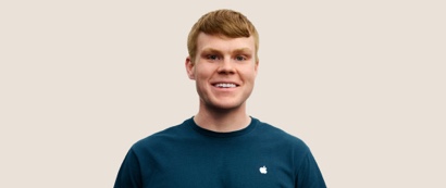 人像相片，相中的 Apple Retail 團隊成員留有深金色短髮，面帶微笑。