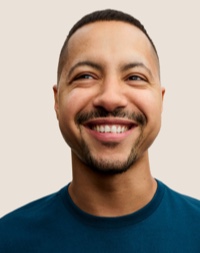 人像相片，相中的 Apple Retail 團隊成員留有深色短髮和鬍鬚，面帶微笑。