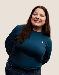 人像相片，相中的 Apple Retail 團隊成員留有深色長髮，面帶微笑。