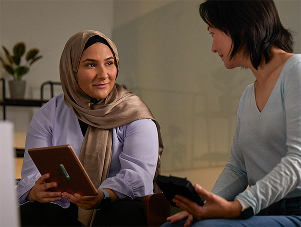 Az Apple Gépi tanulás és MI csapatának két tagja együtt dolgoznak, egyikük egy iPadet, másikuk egy iPhone-t tart a kezében.