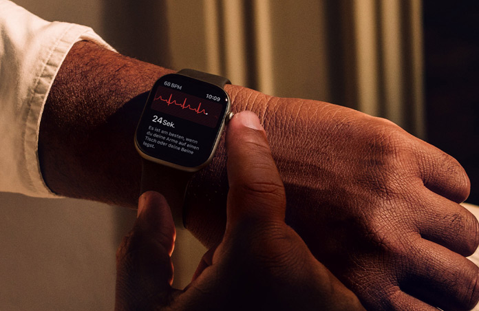Eine Person hält die Digital Crown auf der Apple Watch Series 11 gedrückt, um ihre Herzgesundheit mit der EKG App zu messen