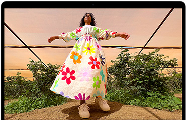 Layar MacBook Air menampilkan foto seseorang mengenakan pakaian berwarna-warni, yang memperlihatkan color range dan resolusi layar Liquid Retina