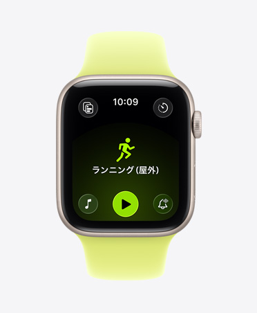 スターライトアルミニウムケースのApple Watch SE 3。屋外ランニングのワークアウトが開いていて、画面の下部にApple Musicの再生ボタンが表示されている。ネオンイエローのスポーツバンドが付いている