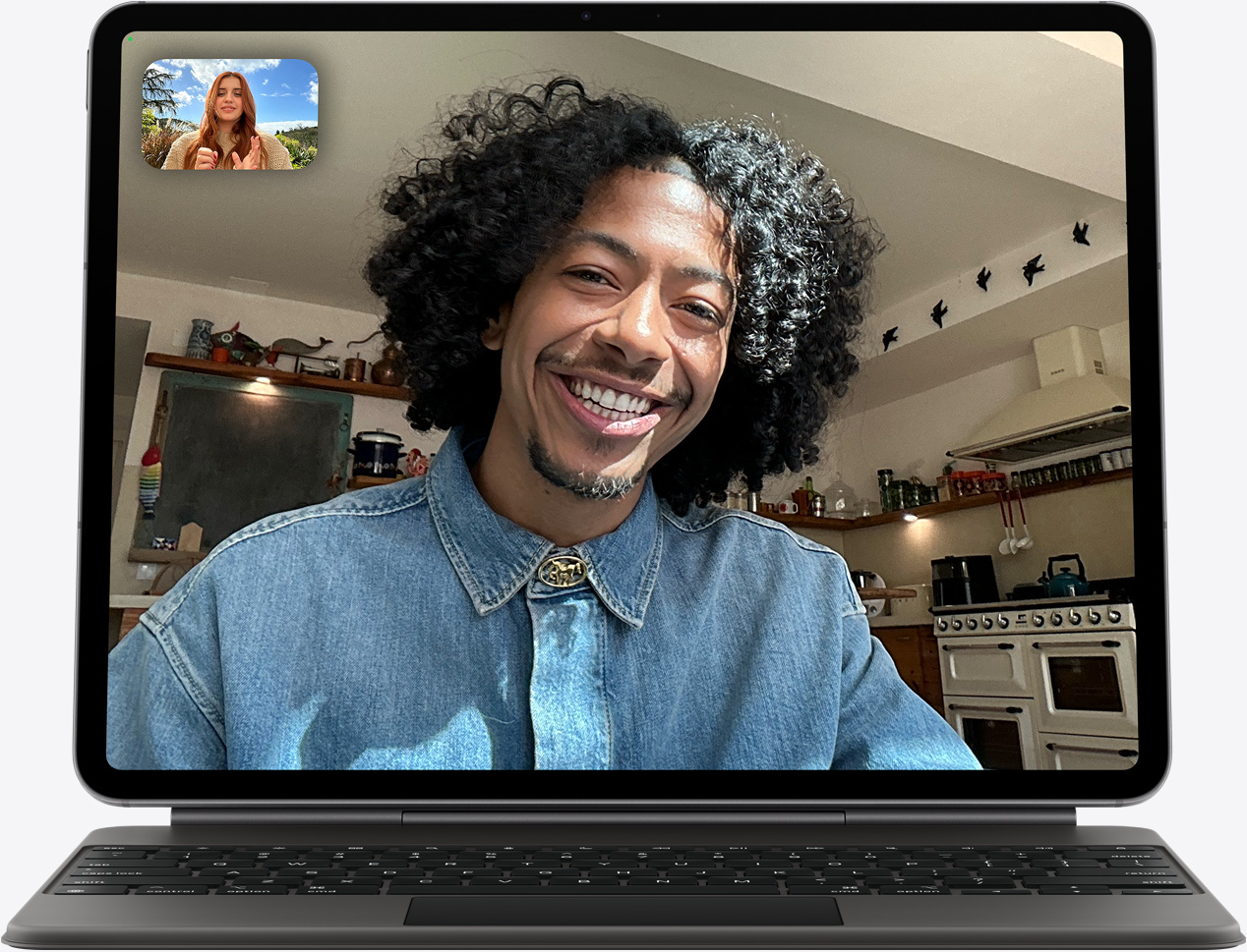 جهاز iPad Air، الجانب الأمامي الخارجي، لوحة مفاتيح ماجيك، لون أسود، مكالمة فيس تايم على الشاشة، يظهر مشاركون متعددون