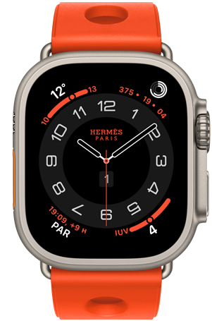 Apple Watch Hermès Ultra 3, carátula analógica Circulaire, (agujas de hora, minuto y segundo, complicaciones: Clima, círculos de Actividad, hora de París e Índice UV), caja de titanio, color natural, parte lateral derecha, Digital Crown, botón lateral en relieve, con la correa Scub'H Diving, color Orange Néon (naranja brillante), fabricada con goma moldeada, aberturas circulares en el centro