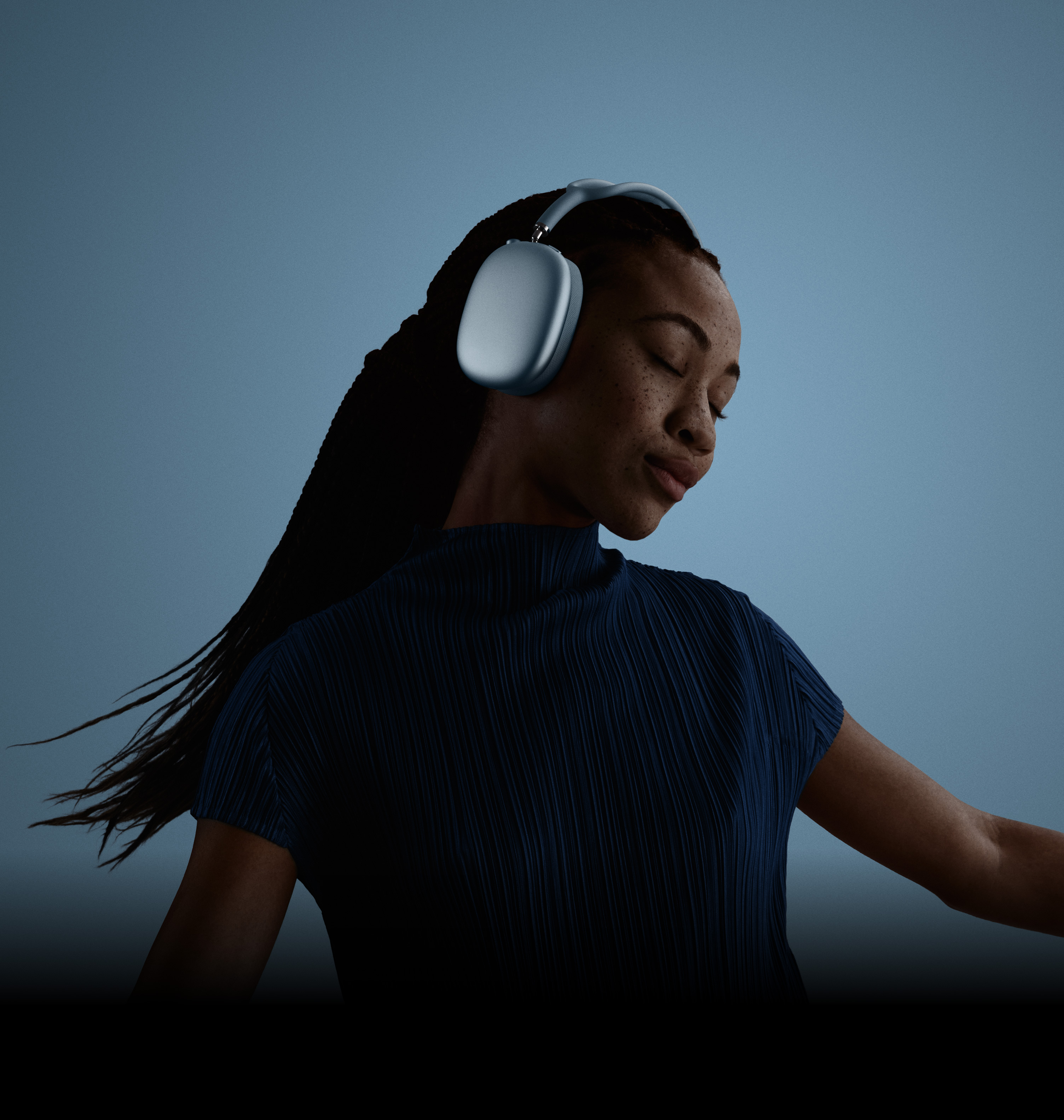 Sieviete ar aizvērtām acīm un pa kreisi pieliektu galvu, valkājot AirPods Max.