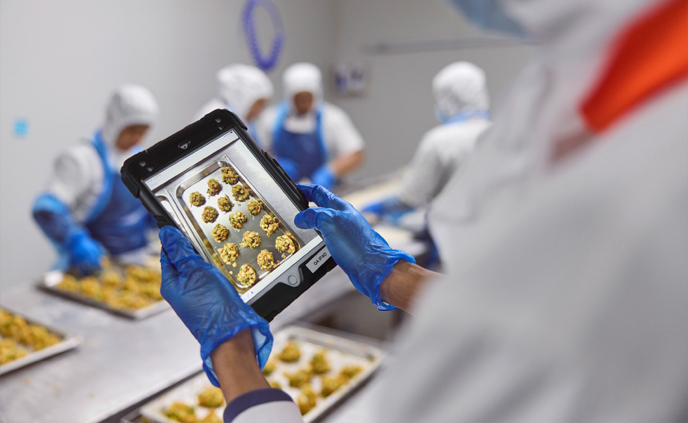 Una dipendente usa un iPad per il controllo qualità.