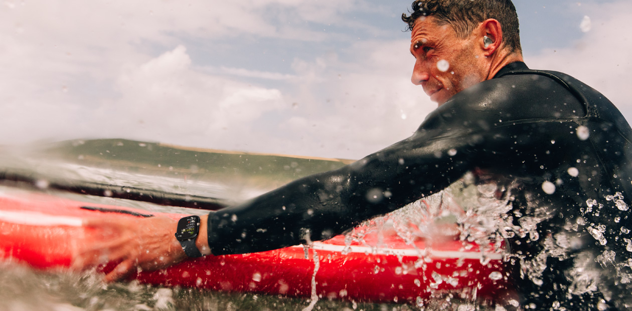 Apple Watchを装着してサーフィンをする男性