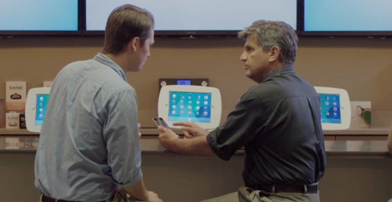 Deux hommes installés au O Bar regardent l’écran d’un iPhone.