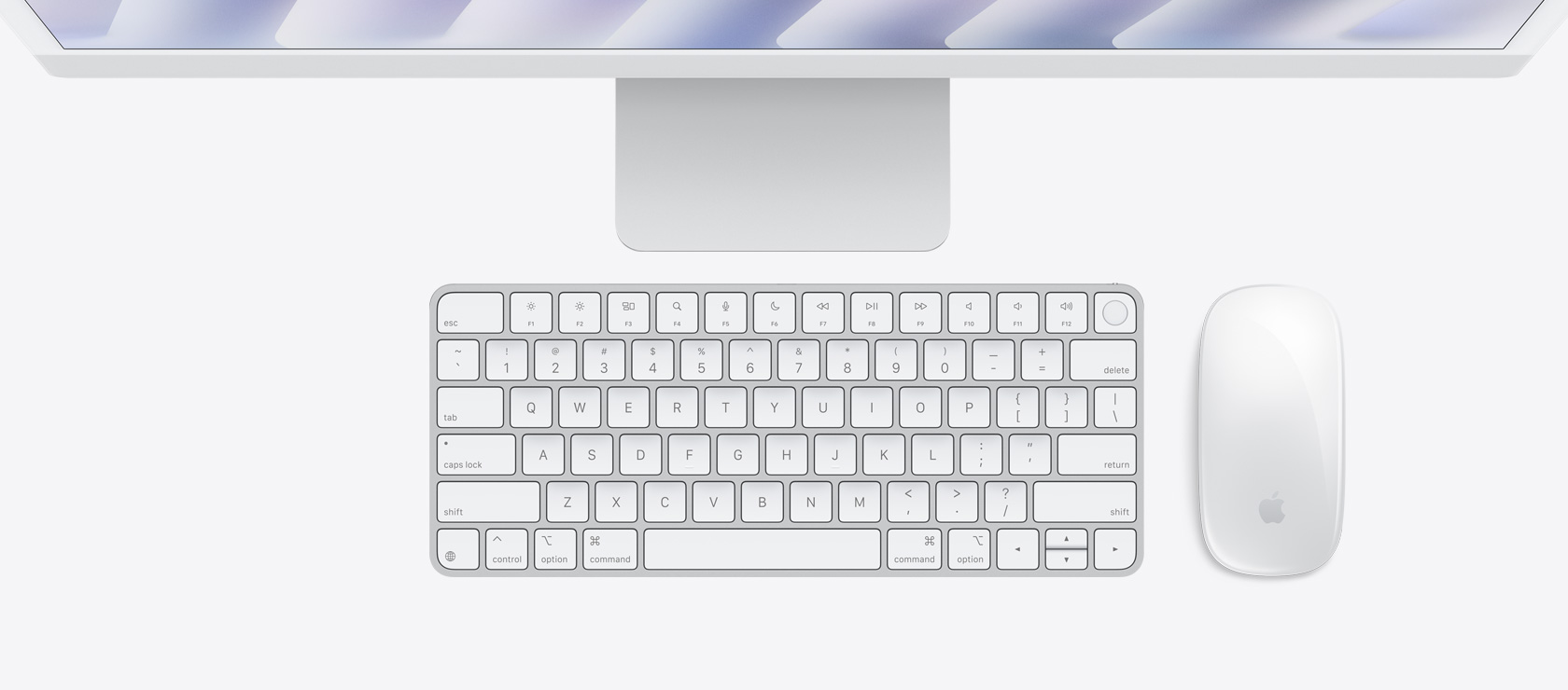 Skats no augšas uz sudraba krāsas iMac ar pieskaņotas krāsas peli un tastatūru