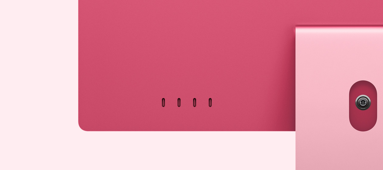 Skats no aizmugures uz rozā iMac, redzami četri USB‑C porti