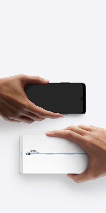 Rokas apmainās ar tālruņiem, pa kreisi ir Android bez kastītes, pa labi ir jauns iPhone Air kastītē