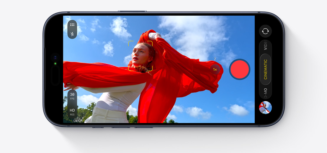 iPhone skats no priekšas, horizontāls, divi cilvēki mašīnā uzņem selfija video ar Center Stage priekšējo kameru, ap sejām ir dzelteni kvadrāti, kas parāda automātisko kadrēšanu