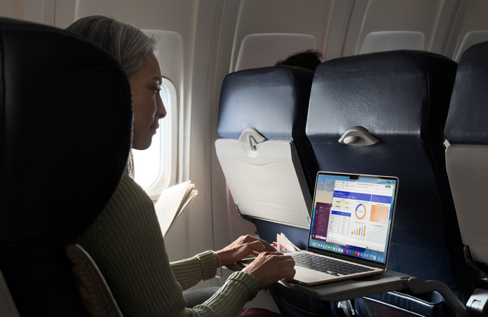 Pessoa trabalha no MacBook Air em uma poltrona de avião