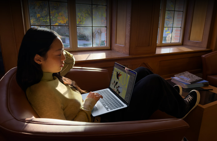 Pessoa sentada em uma cadeira usando um MacBook Air