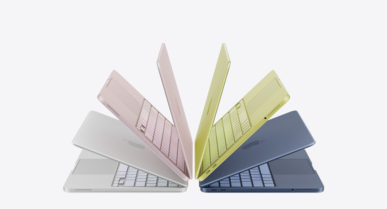 MacBook Neo portatīvie sudraba, maigi sārtā, citrusa un indigo krāsā, pavērti un izkārtoti lokā