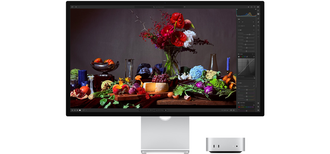 Augsta kontrasta attēls – galds ar dažādiem ēdieniem un ziedu pušķi uz tumša fona. Tā tiek parādīts, kā True Tone pielāgo krāsas temperatūru.